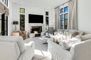 Relax in style with a large flat-screen TV above the fireplace, a comfortable sofa set, and ample seating for socializing.