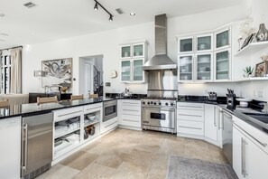 Enjoy cooking in this well-equipped kitchen with a dishwasher, stainless steel refrigerator, and spacious countertop area.