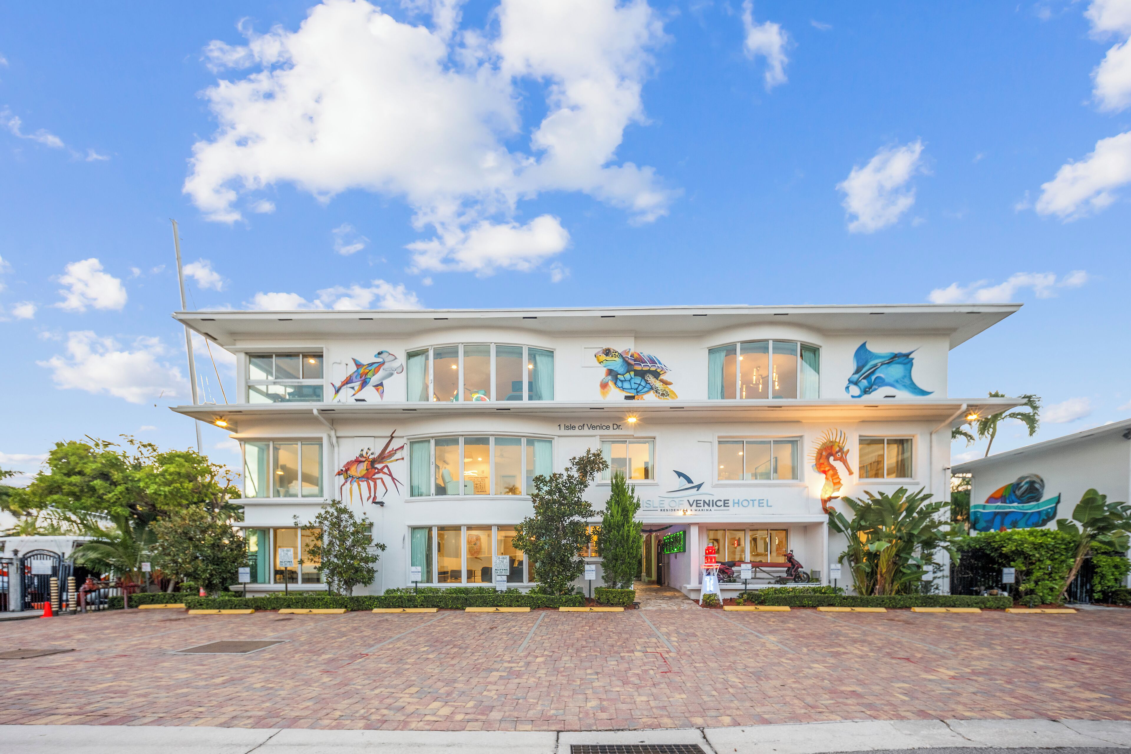 A hotel with a two-story structure, featuring a prominent sea turtle mural on the facade.