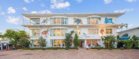 A hotel with a two-story structure, featuring a prominent sea turtle mural on the facade.