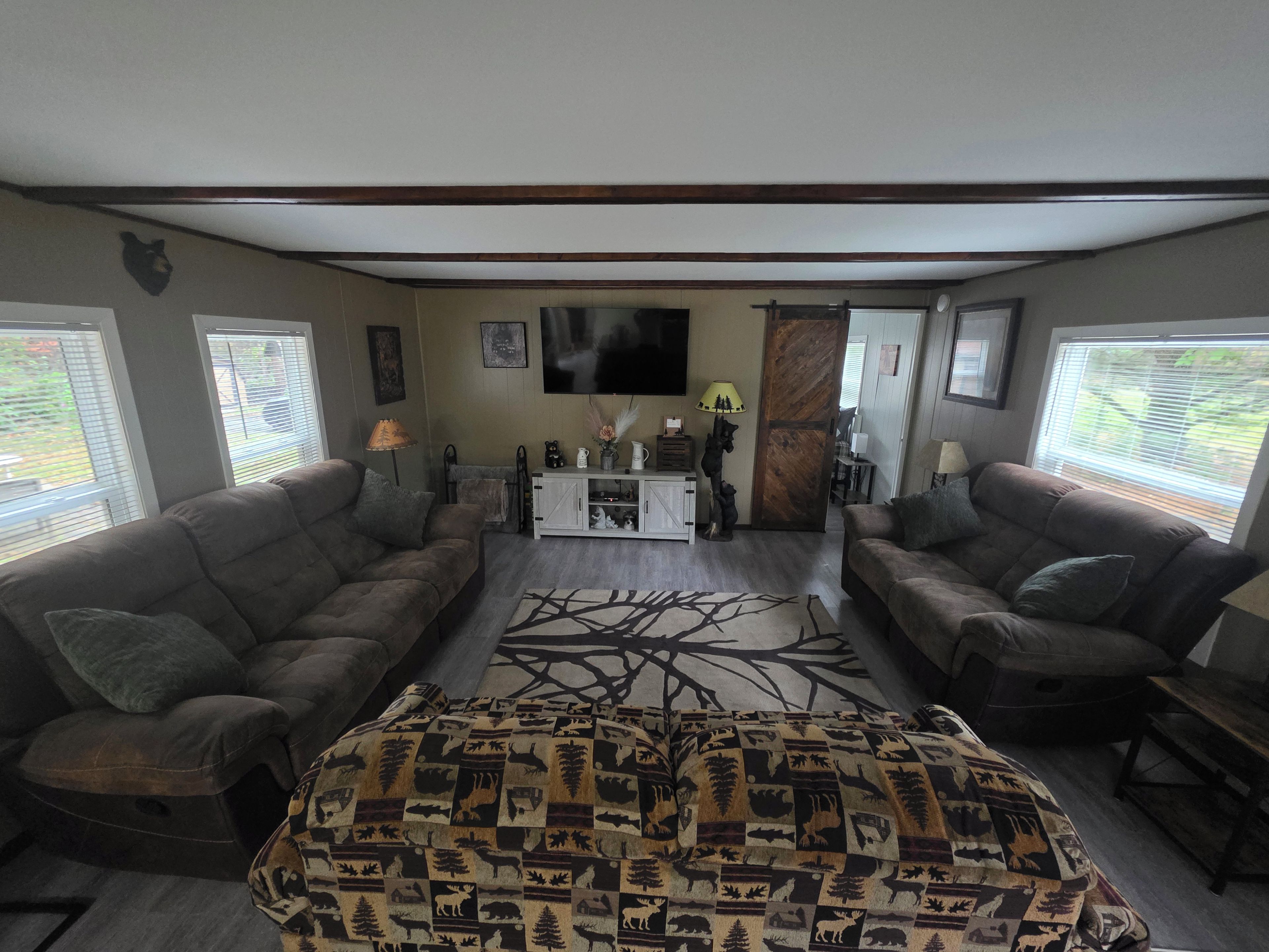 A living room with two sofas, a coffee table, a TV, and a patterned rug.