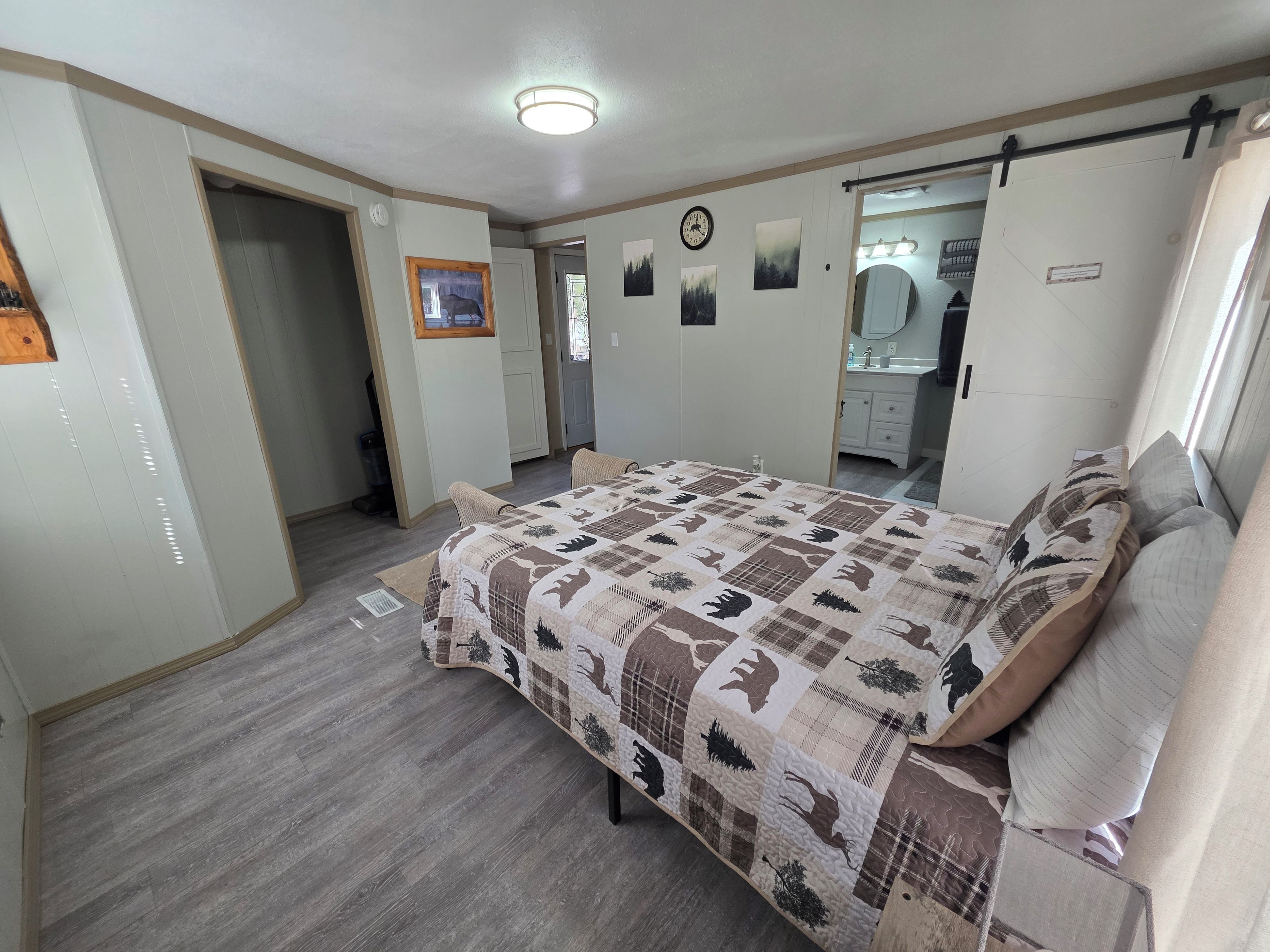 A bedroom with a bed, a wardrobe, a mirror, and a door leading to a bathroom.