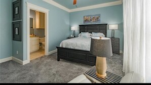 A bedroom with a bed, a ceiling fan, a nightstand, a lamp, and a painting on the wall. - Coastal Condo w/ Pool, Balconies, Sundeck & Boat Slip - Near Beach (Corpus Christi)