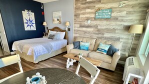 A cozy room with a bed, a sofa, a small table, and a round table with a decorative item.
