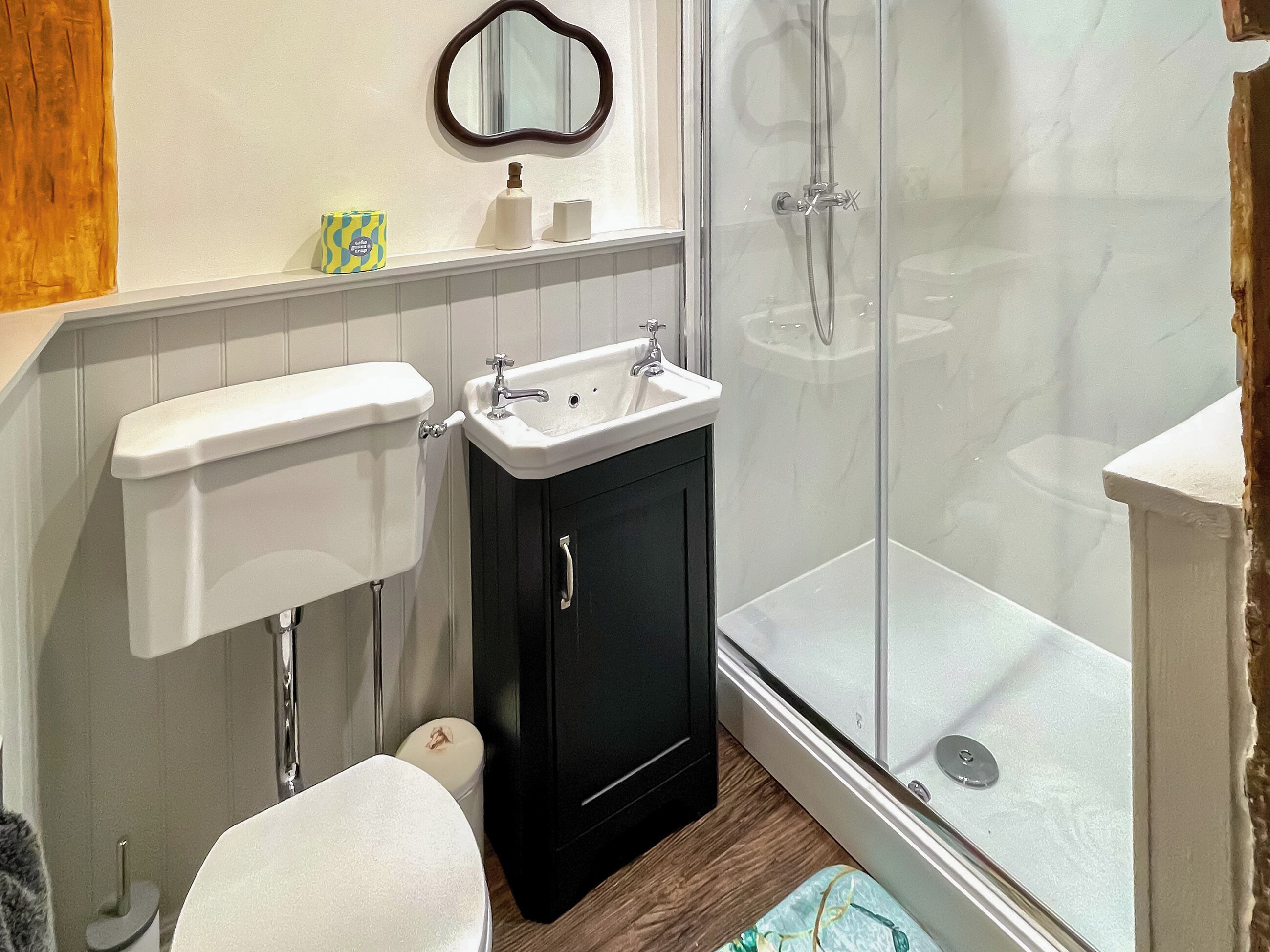 Une salle de bain avec des toilettes, un lavabo et une douche.