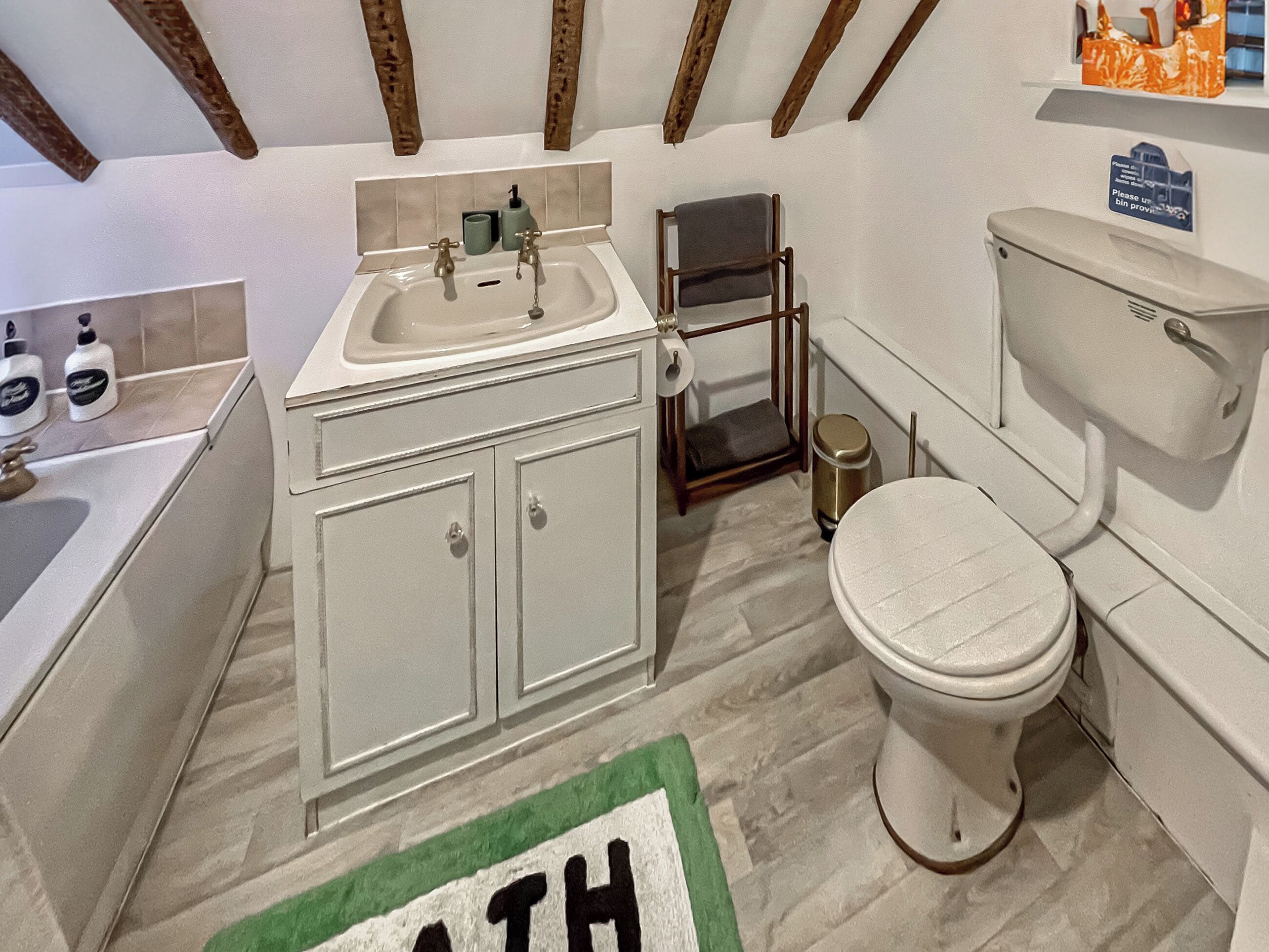 A bathroom with a sink, toilet, and shower area.