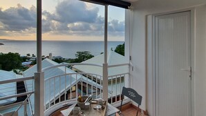 A balcony with a view of the sea, a door, and a table with items on it. - #Enjoy the charm of Studios 309 AbricotPays # (La Trinité)