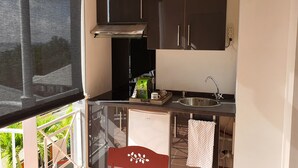 A compact kitchen with a sink, a stove, and a refrigerator. - #Enjoy the charm of Studios 309 AbricotPays # (La Trinité)