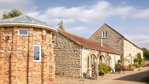 A traditional stone building with a brick structure, a stone roof, and a gravel driveway. - A relaxing, rural retreat for two. (Wrelton, near Pickering)