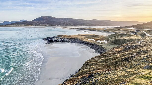 A coastal landscape with a beach, rocky shoreline, and distant mountains. - 1 bedroom accommodation in Leverburgh, Isle of Harris (Leverburgh, Isle of Harris)