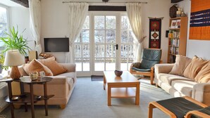 A cozy living room with a sofa, armchairs, a coffee table, and a television. - 3 bedroom accommodation in Kirkby Stephen (Kirkby Stephen)