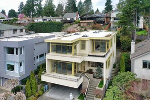 A modern two-story house with a flat roof, large windows, and a small front yard. - Unique Seattle Gem: 5BR + 3.5BA w/ lake & mountain views, AC, close to transit (Seattle)