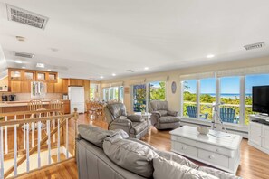A spacious living area with a kitchen, dining space, and a balcony with a view.