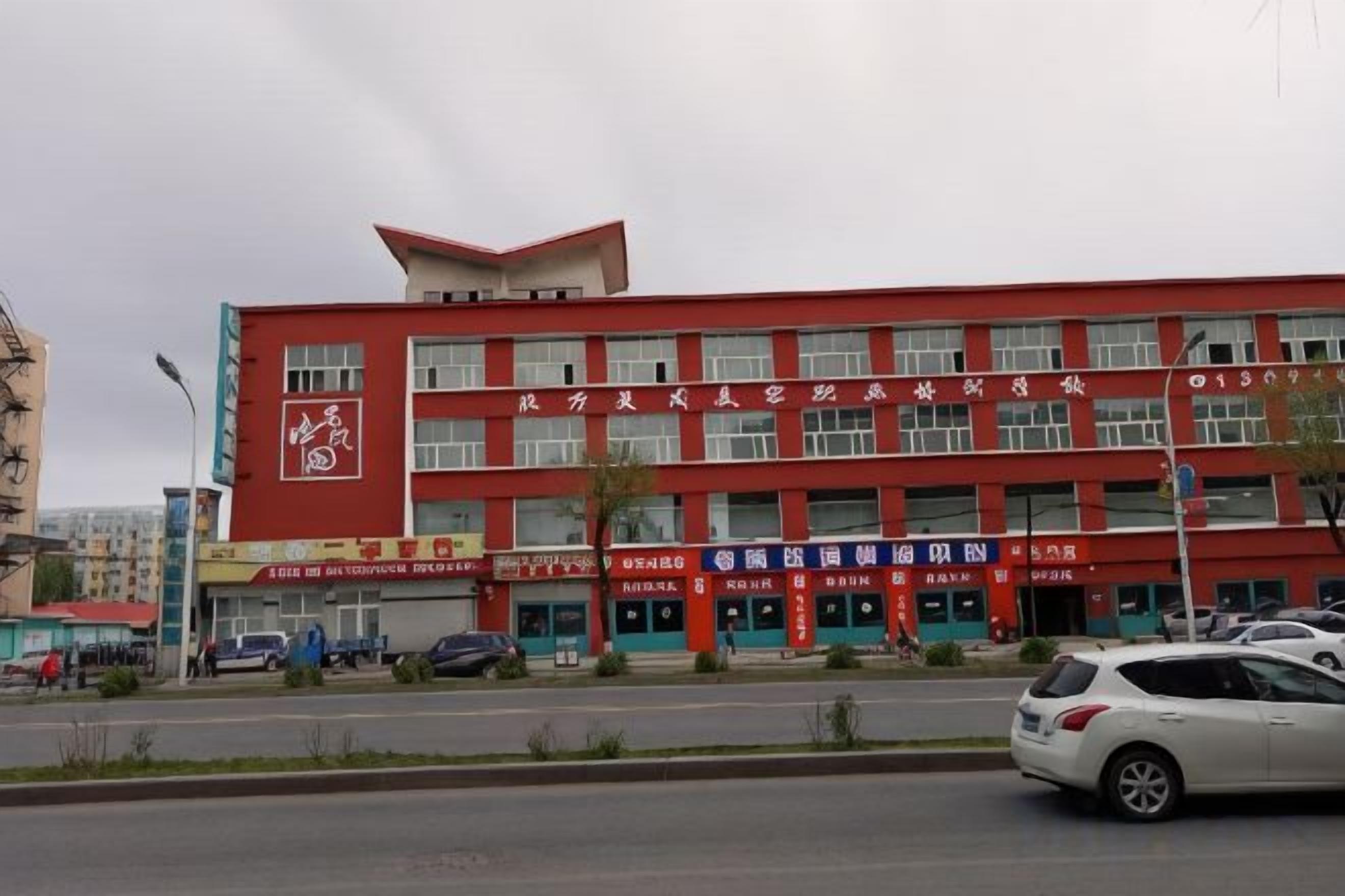 Un edificio de varios pisos con letreros de diferentes negocios en la planta baja.