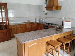 A kitchen with wooden cabinets, granite countertops, a gas stove, a microwave, and a coffee maker.