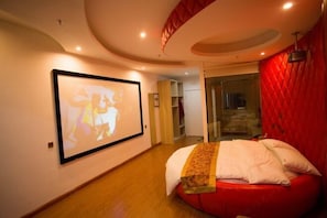 Un dormitorio moderno con techo curvo, una cama grande y un proyector montado en la pared.
