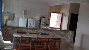 A spacious living area with a dining table and chairs, a kitchen with modern appliances, and a large window providing natural light. - Country house in Araçoiaba da Serra (Araçoiaba da Serra)