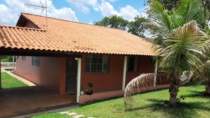 A single-story house with a tiled roof, a small porch, and a palm tree in the yard. - Country house in Araçoiaba da Serra (Araçoiaba da Serra)