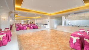 A spacious hall with multiple round tables covered in pink tablecloths, arranged for an event. - Baiyunbao International Hotel (Wangcang)
