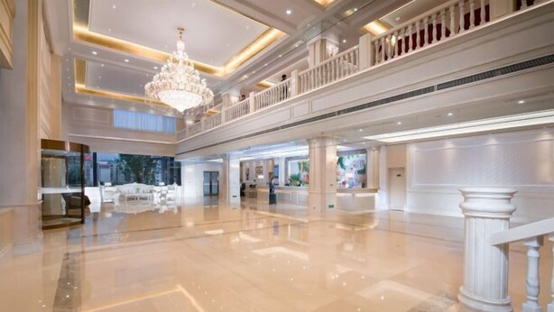 A spacious lobby with a grand chandelier, multiple levels, and a polished marble floor. - Baiyunbao International Hotel (Wangcang)