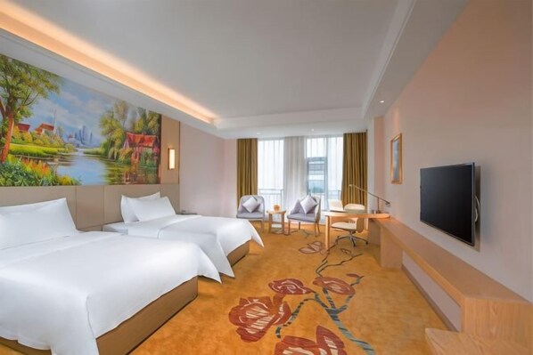 A hotel room with two beds, a TV, a desk with a chair, and a painting on the wall.