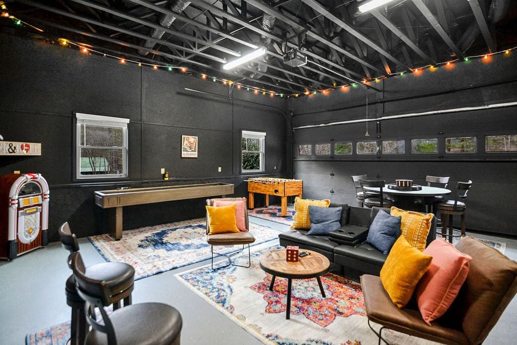 A cozy room with a pool table, comfortable seating, and string lights.