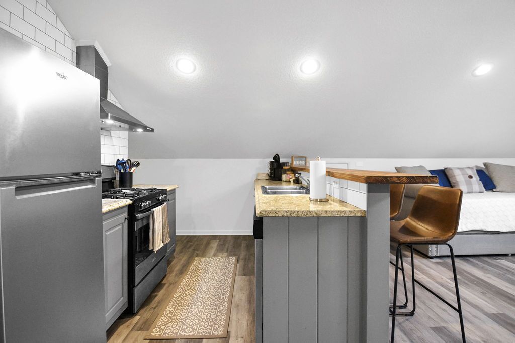 A compact kitchen with a built-in stove, a refrigerator, and a small island with a sink.