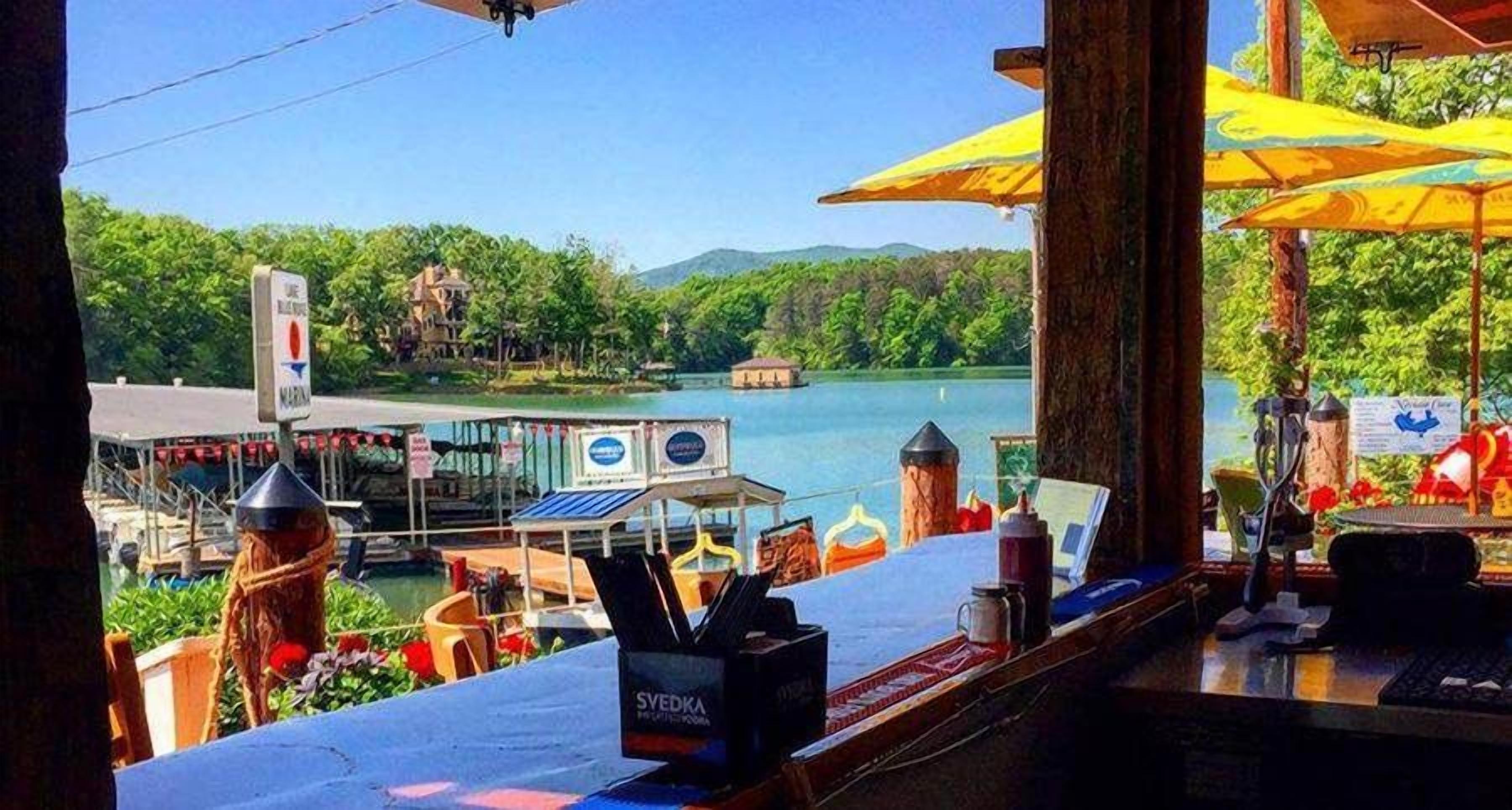 A waterfront bar with a view of a lake and boats.