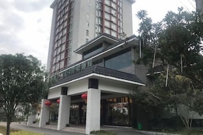 A multi-story hotel with a modern design, featuring a prominent entrance with a covered walkway and red lanterns. - Pristime International Holiday Hotel (Yinjiang)