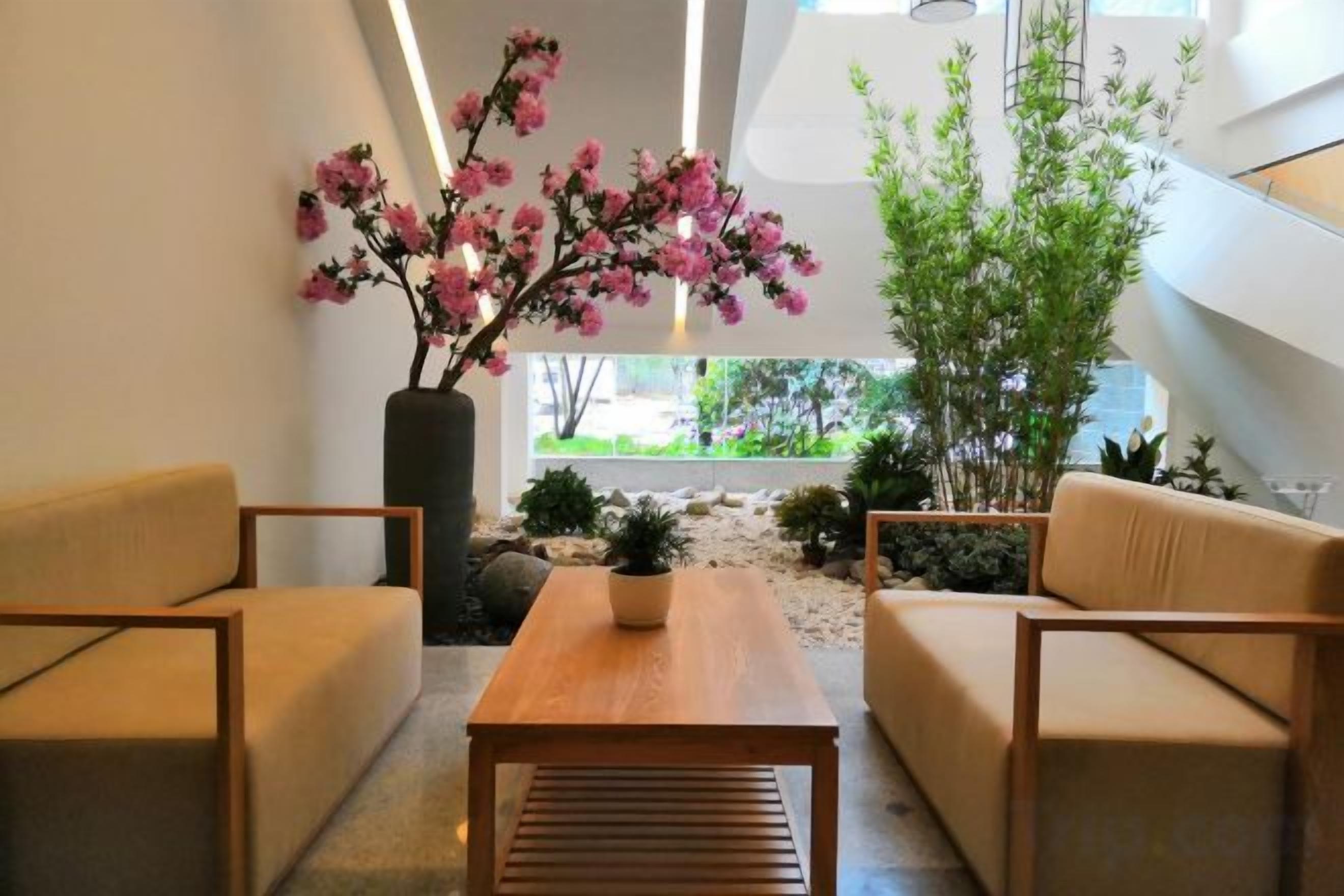 Un interior moderno con un sofá, una mesa de madera y plantas en macetas.