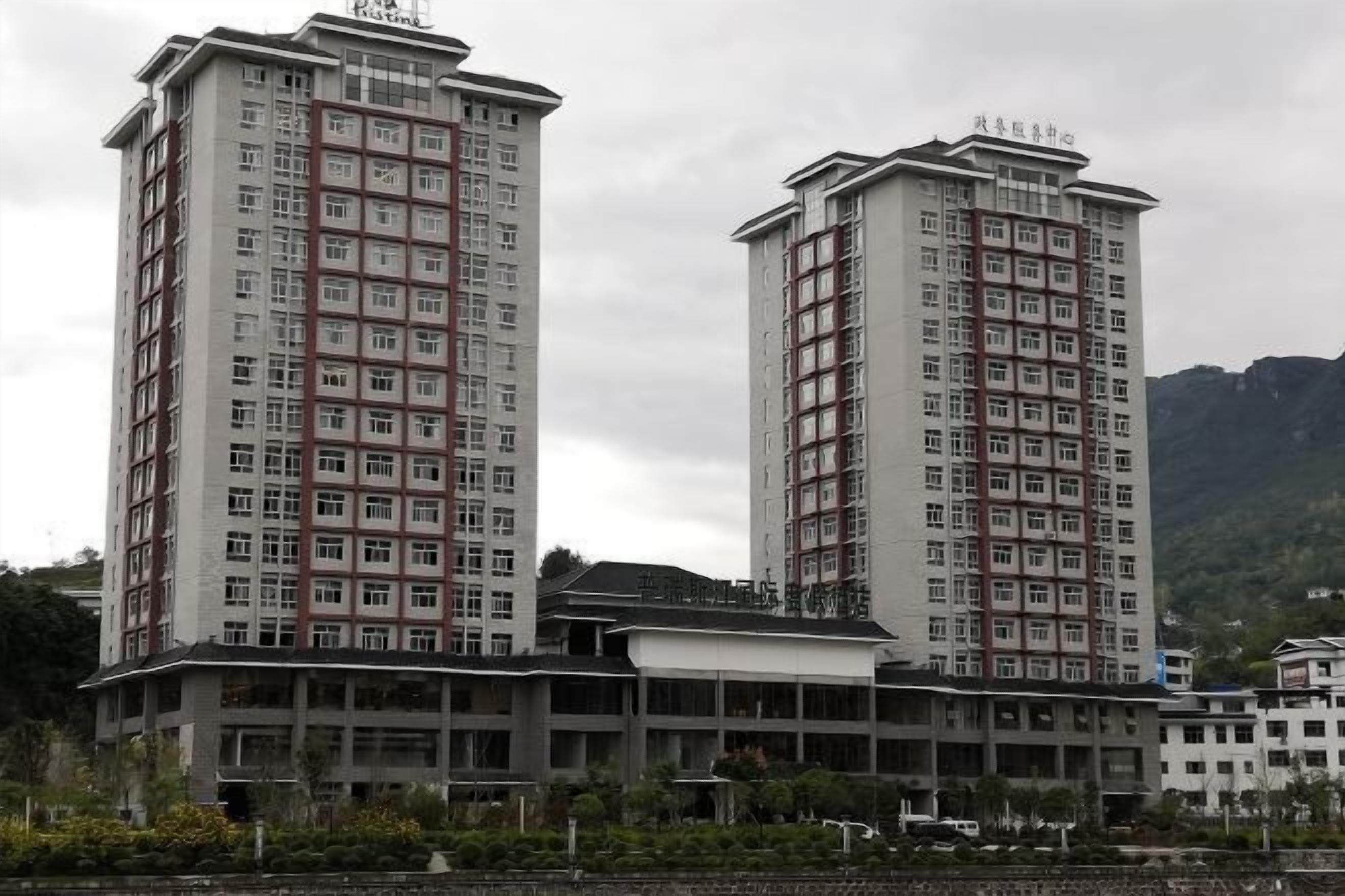 Two high-rise buildings with multiple floors, likely residential or office buildings, with a flat roof and a uniform facade.