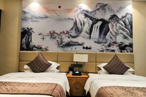 A hotel room with two beds, a large wall mural of a mountainous landscape, and a wooden nightstand with a lamp. - Pristime International Holiday Hotel (Yinjiang)