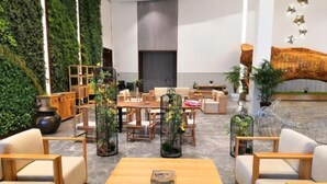 A modern lobby with a seating area, wooden furniture, and green walls.