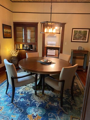 Enjoy meals in this dining area with a round table and six chairs, a placemat, and a decorative item.
