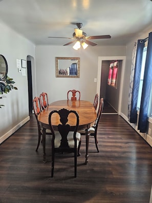 A dining area with a round table, chairs, a ceiling fan, and a mirror on the wall. - Spacious 4 bedrooms, 6 beds, 2 baths (Detroit)