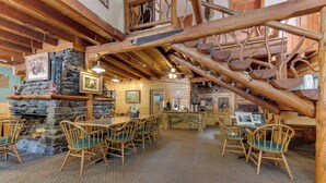 A rustic interior with wooden furniture, stone walls, and a staircase with wooden steps. - Cottonwood Cove (South Fork)