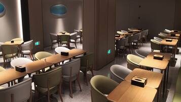 A modern conference room with multiple tables and chairs, equipped with built-in lighting and a central pillar.