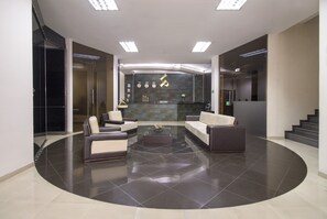 A modern lobby with a curved seating area, a reception desk, and a staircase. - Hotel Luxor Plaza Pereira (Pereira)