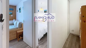 A bedroom with a bed, a wooden bench, and a wall-mounted heater.