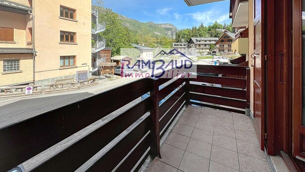 A balcony with a view of a mountain and buildings in the background.