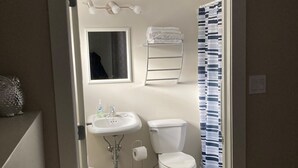 Ein kleines Badezimmer mit Toilette, Waschbecken und Handtuchhalter.