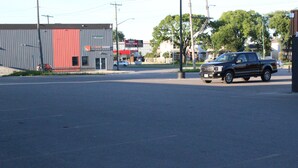 Un estacionamiento con una camioneta negra estacionada a la derecha.
