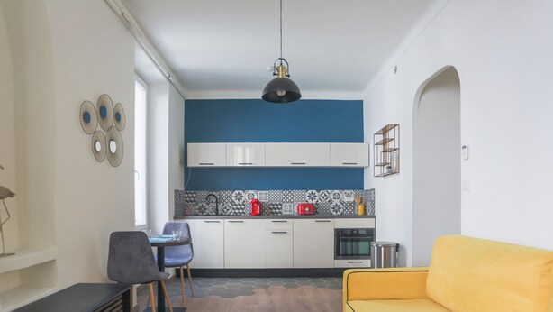 Un espacio habitable compacto con kitchenette, comedor y sofá.