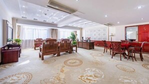 Una habitación de hotel con una cama grande, un escritorio y un comedor con sillas.