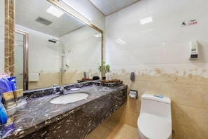 A bathroom with a marble sink, a toilet, and a mirror. - Hongrui Holiday Hotel (Linxia)