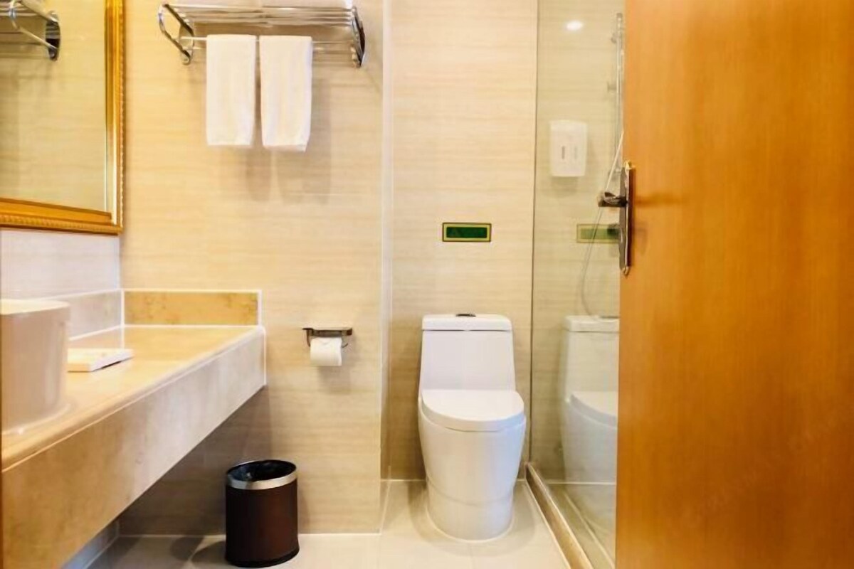 A modern bathroom with a toilet, sink, and shower area.