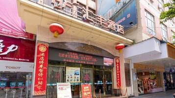 A hotel with a prominent sign, a storefront, and a red lantern.