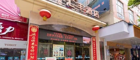 A hotel with a prominent sign, a storefront, and a red lantern.