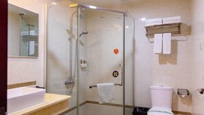 A modern bathroom with a glass-enclosed shower, a sink, and a toilet.