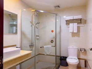 Un baño moderno con ducha de vidrio, lavamanos e inodoro.